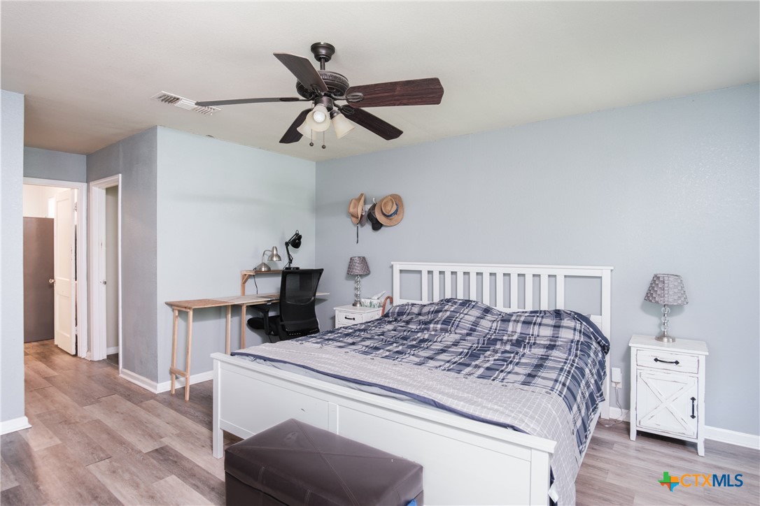 921 South 11th Street Temple, TX 76504 - Photo 21 of 23 a bedroom with a large bed and a chandelier