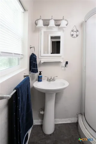a bathroom with a sink toilet and a window