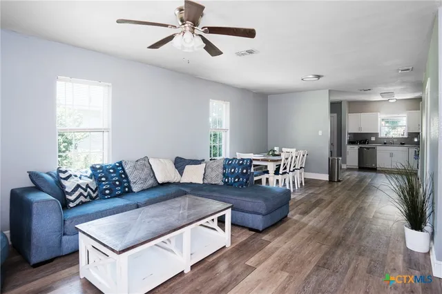 a living room with furniture and a wooden floor
