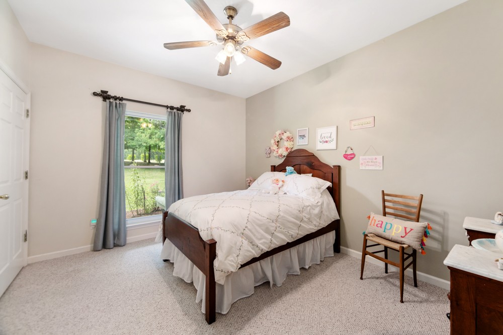 105 Spicer Road Burns, TN 37029 - Photo 24 of 44 a bed room with a bed and a chandelier