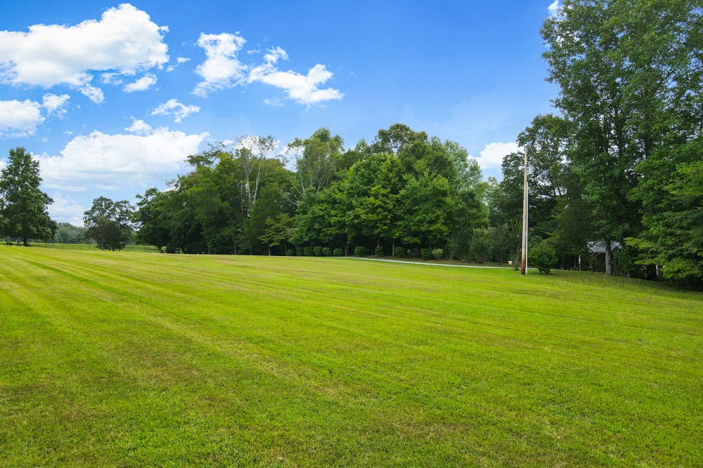 105 Spicer Road Burns, TN 37029 - Photo 39 of 44 a view of a big yard with swimming pool and green space