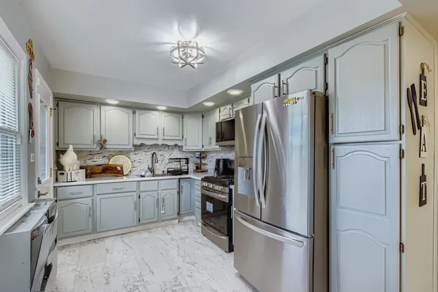 a kitchen with stainless steel appliances a refrigerator sink and cabinets