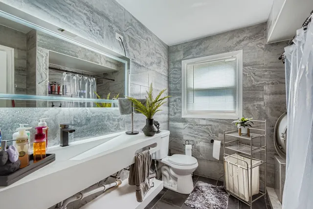 a bathroom with a sink toilet and mirror