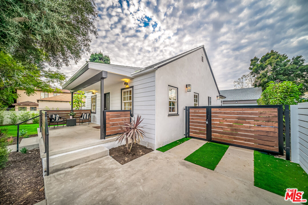 5619 Bellingham Avenue Valley Village, CA 91607 - Photo 1 of 48 a view of a house with a yard and table and chairs under an umbrella