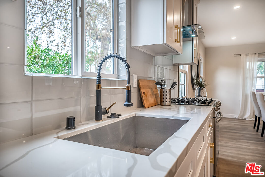 5619 Bellingham Avenue Valley Village, CA 91607 - Photo 11 of 48 a kitchen with stainless steel appliances granite countertop a sink a stove and a wooden floors