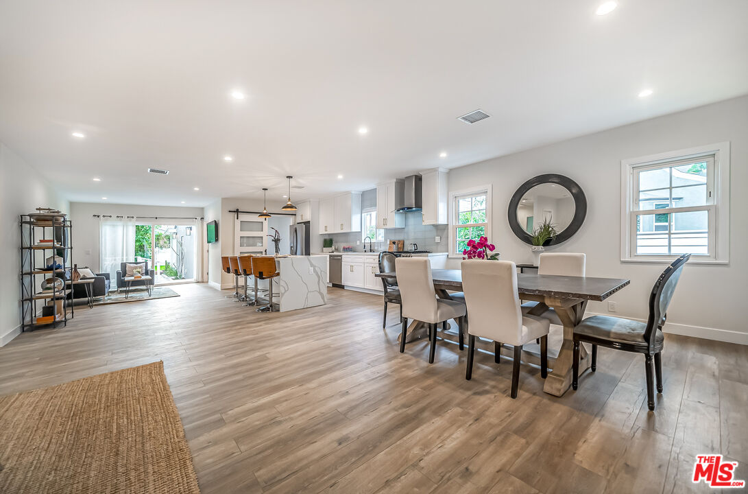 5619 Bellingham Avenue Valley Village, CA 91607 - Photo 12 of 48 a dining room with wooden floor a glass table and chairs