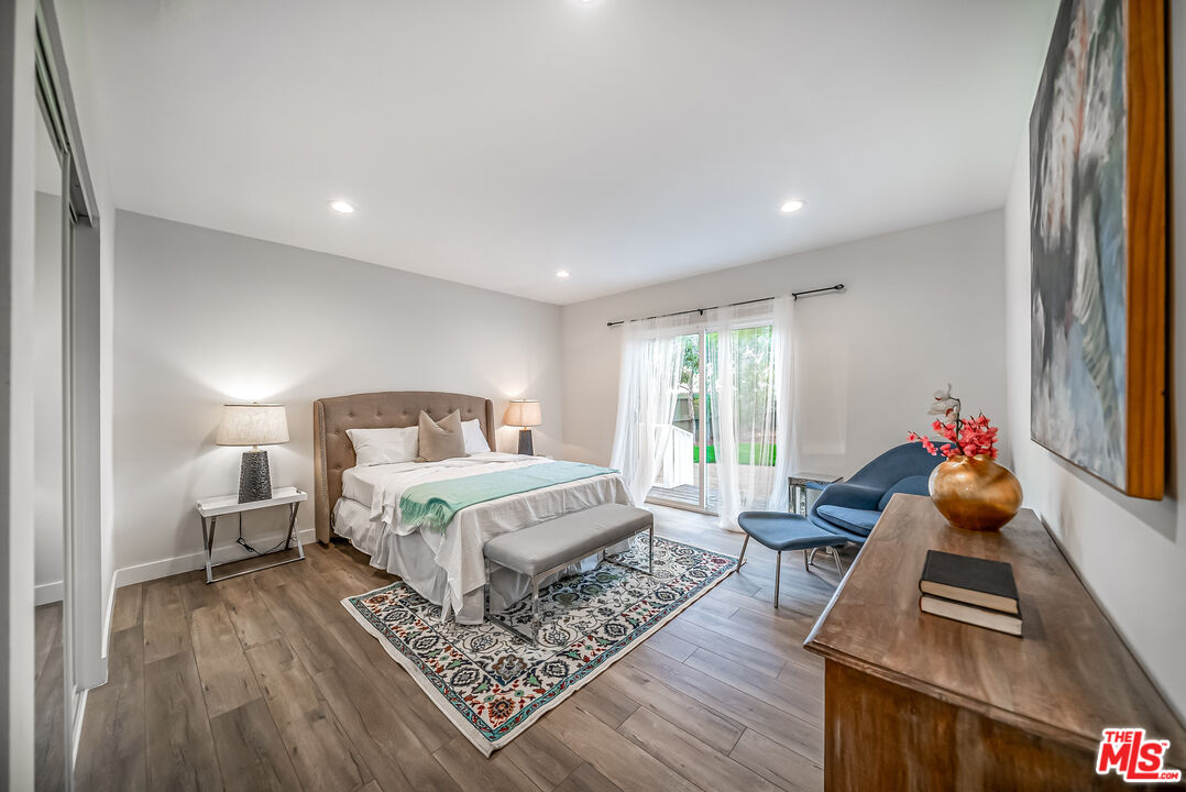 5619 Bellingham Avenue Valley Village, CA 91607 - Photo 22 of 48 a spacious bedroom with a bed and wooden floor