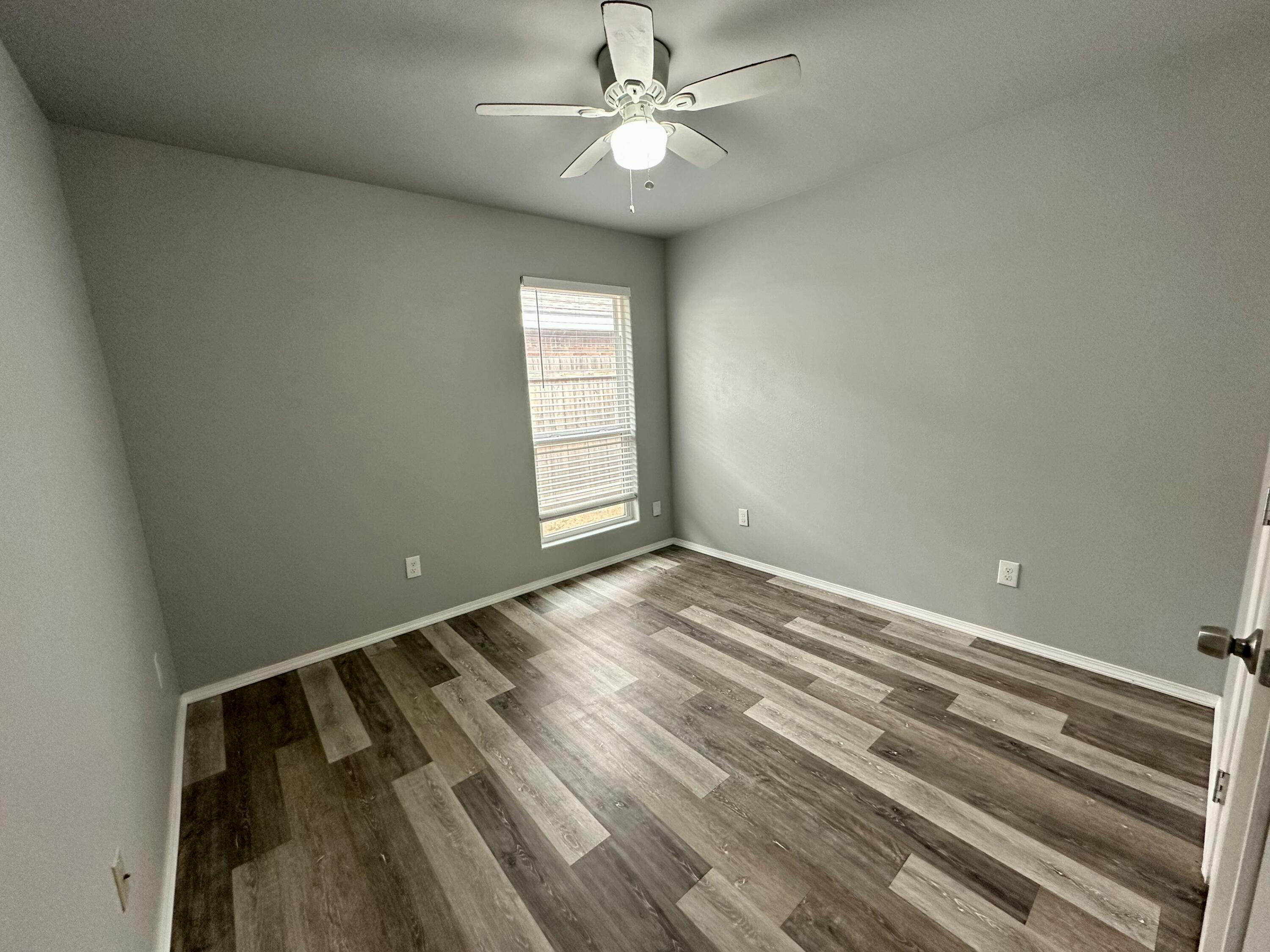 8434 11th Street Lubbock, TX 79416 - Photo 11 of 11 a view of an empty room and window chandelier fan