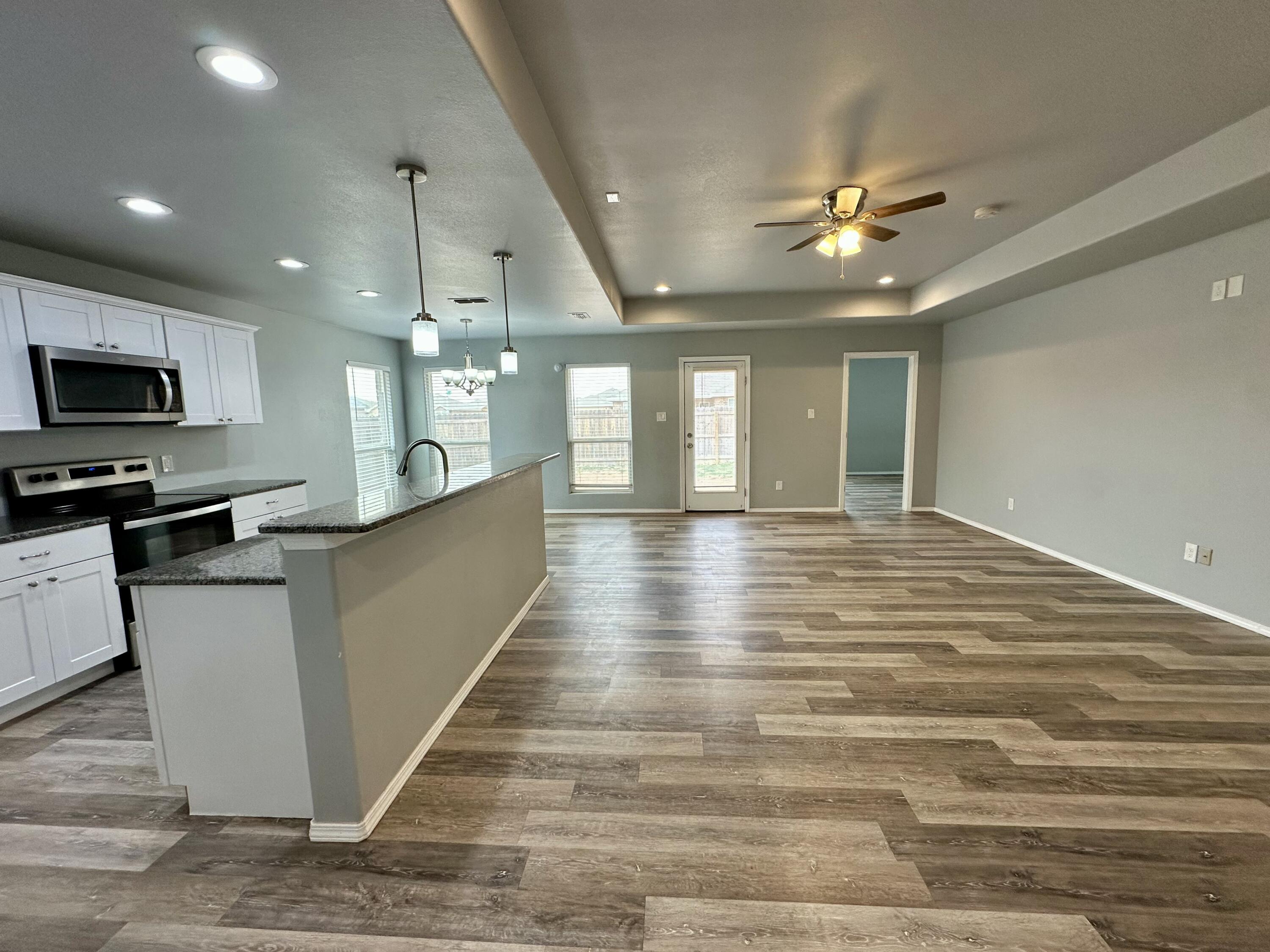 8434 11th Street Lubbock, TX 79416 - Photo 2 of 11 a view of a kitchen with a sink and a microwave