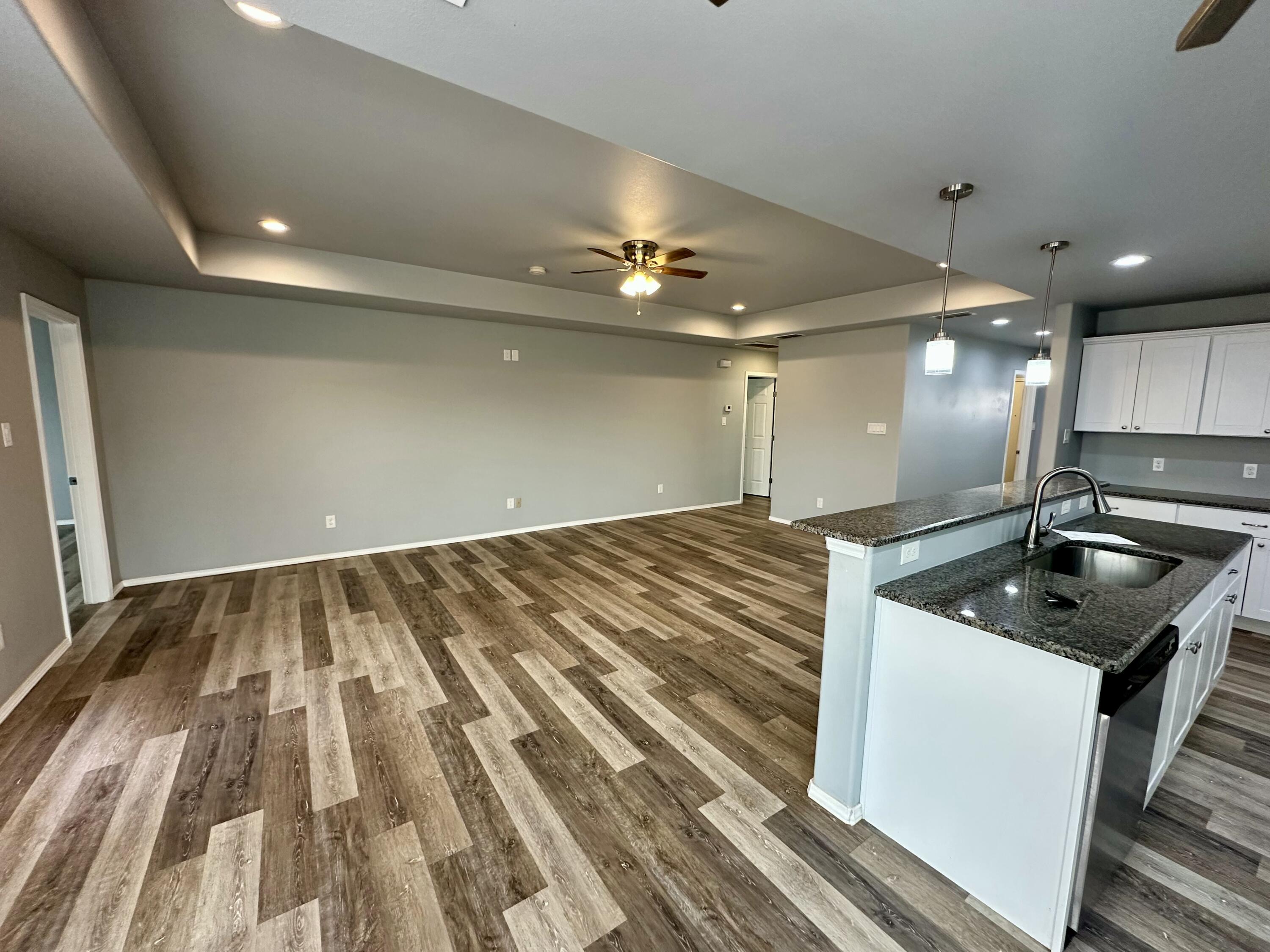 8434 11th Street Lubbock, TX 79416 - Photo 4 of 11 a kitchen with kitchen island a sink stainless steel appliances and cabinets