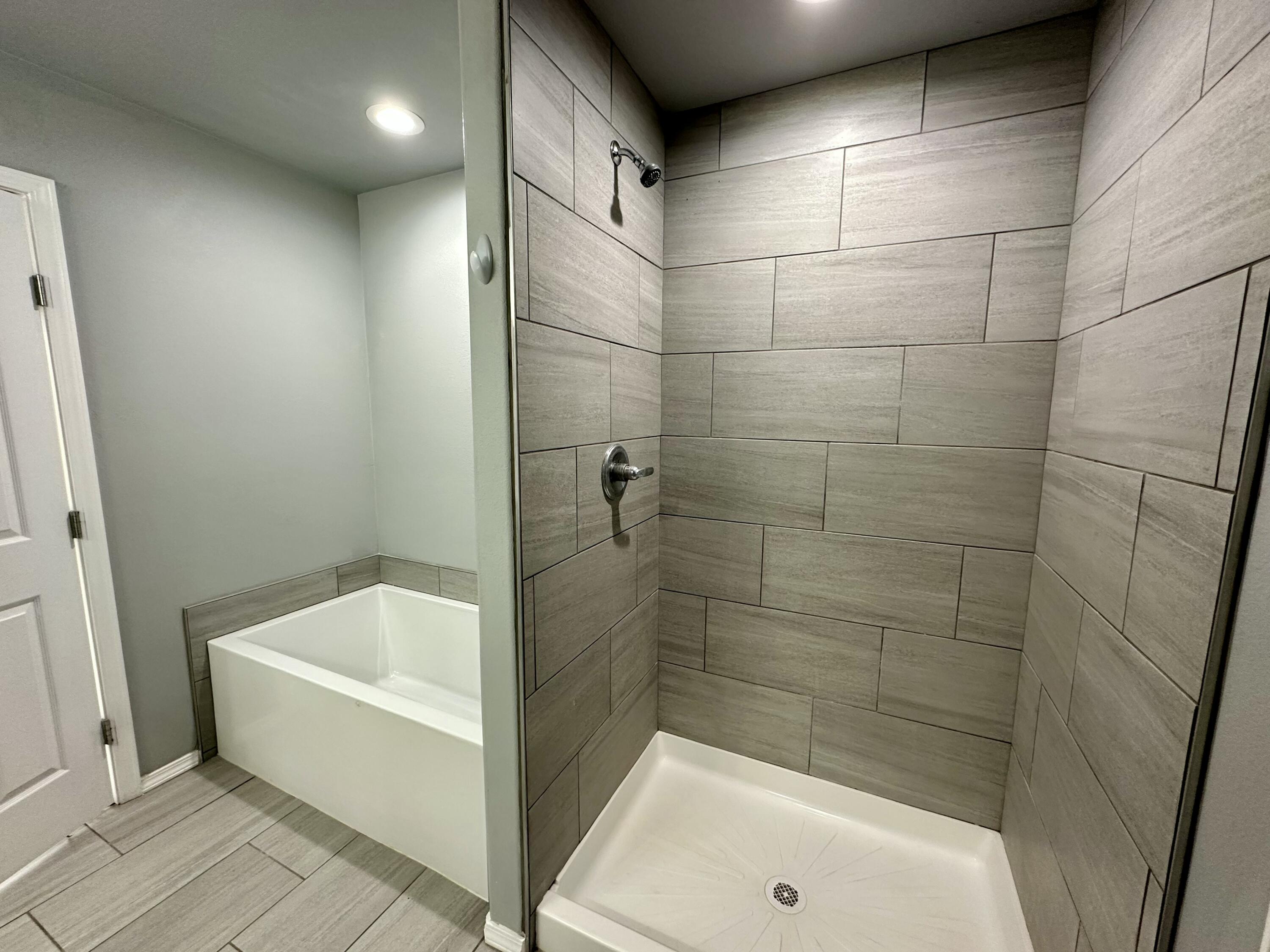 8434 11th Street Lubbock, TX 79416 - Photo 7 of 11 a bathroom with a bathtub and shower