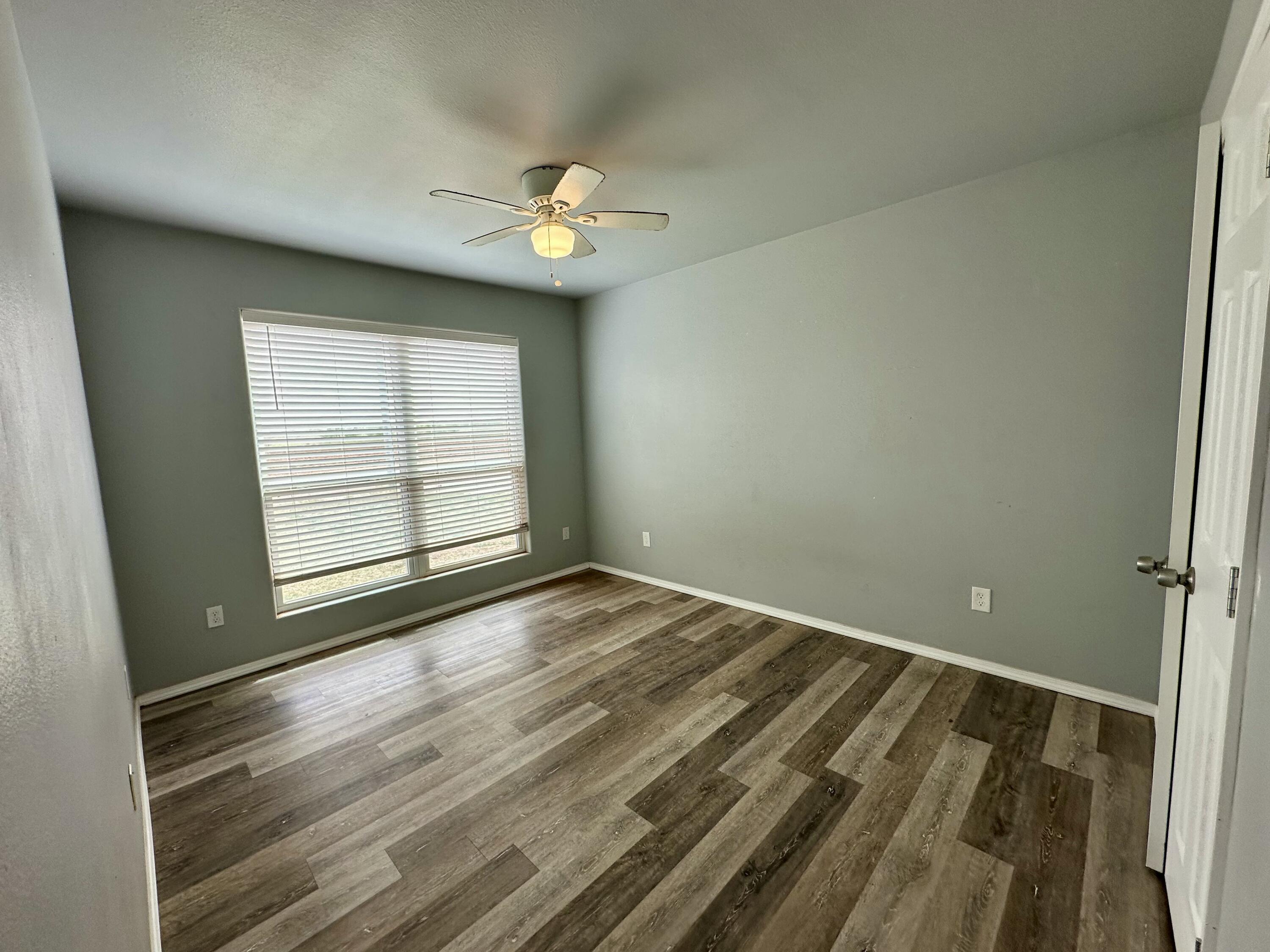 8434 11th Street Lubbock, TX 79416 - Photo 8 of 11 an empty room with wooden floor and windows
