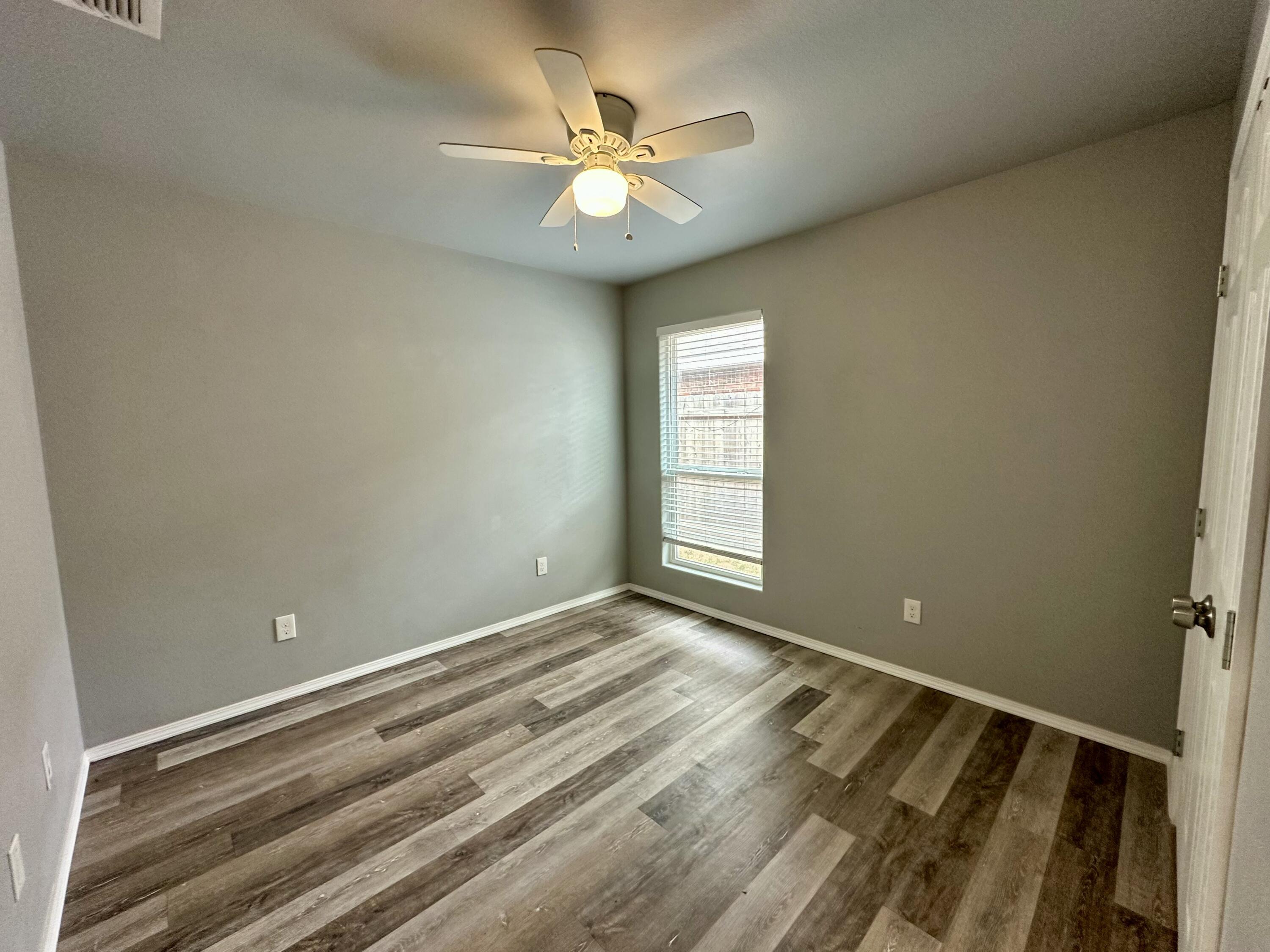 8434 11th Street Lubbock, TX 79416 - Photo 10 of 11 wooden floor and window in an empty room