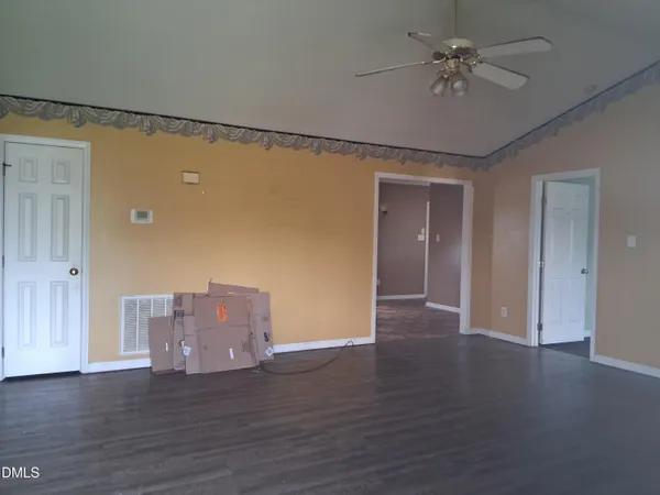 a view of a livingroom with wooden floor and a ceiling fan