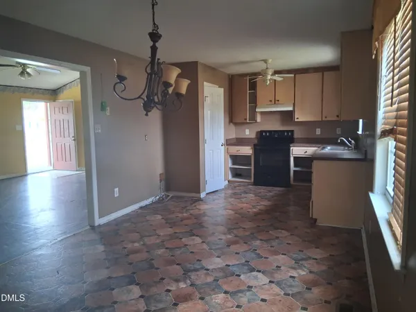 a open kitchen with kitchen island granite countertop a refrigerator stove top oven and sink