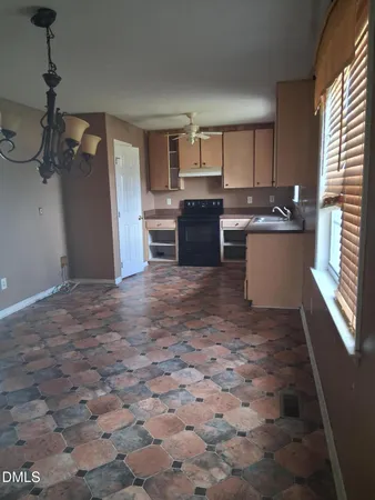 a large kitchen with granite countertop a sink and cabinets