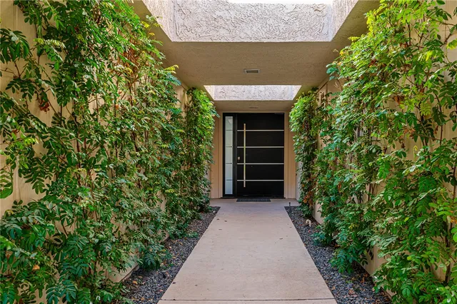 an entrance to house with yard and green space