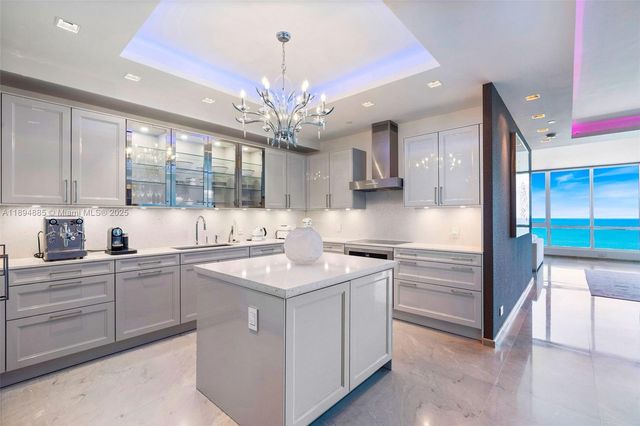 a kitchen with kitchen island granite countertop a sink stainless steel appliances and cabinets