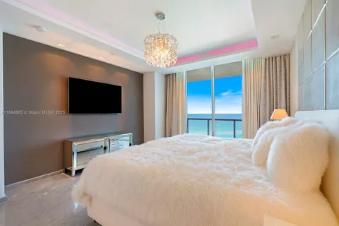 a spacious bedroom with a bed and a flat screen tv