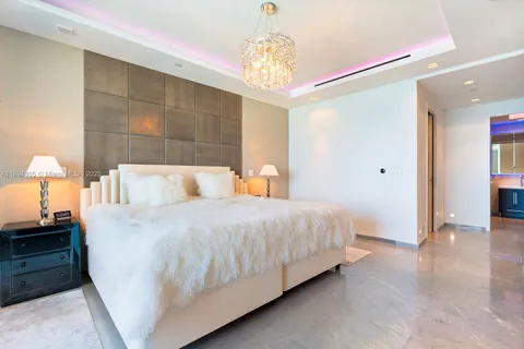 a bedroom with a bed and a chandelier