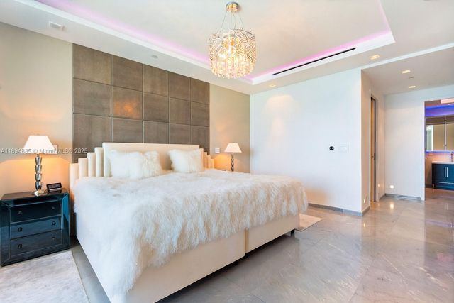 a bedroom with a bed and a chandelier