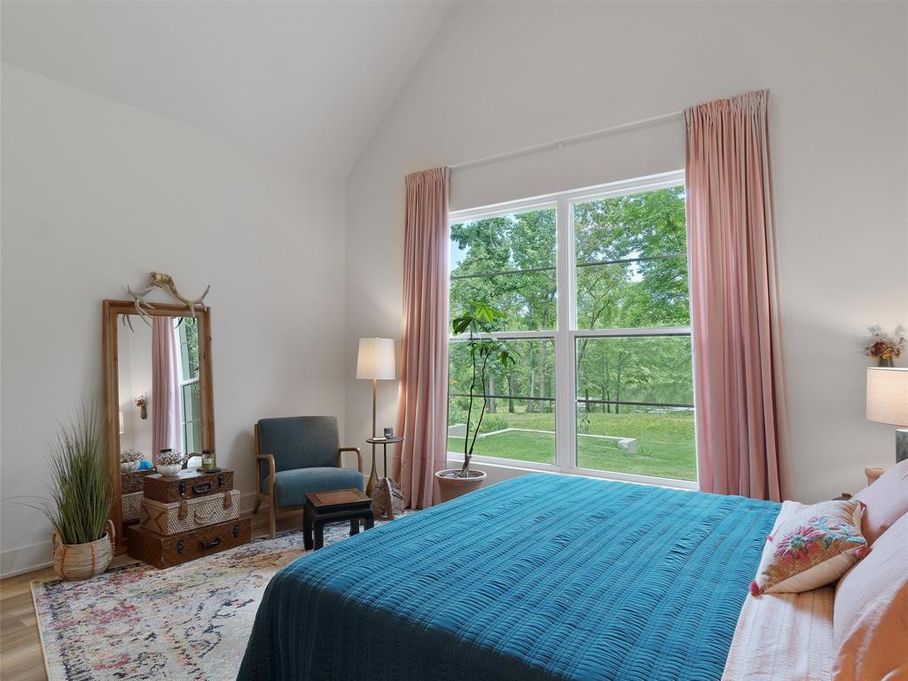 800 John Dean Road Gilmer, TX 75644 - Photo 34 of 40 a bedroom with a bed a large window and walk in closet