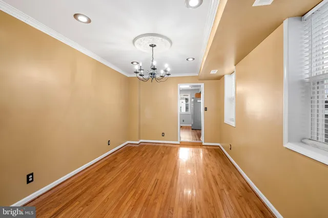 a view of a room with wooden floor and chandelier