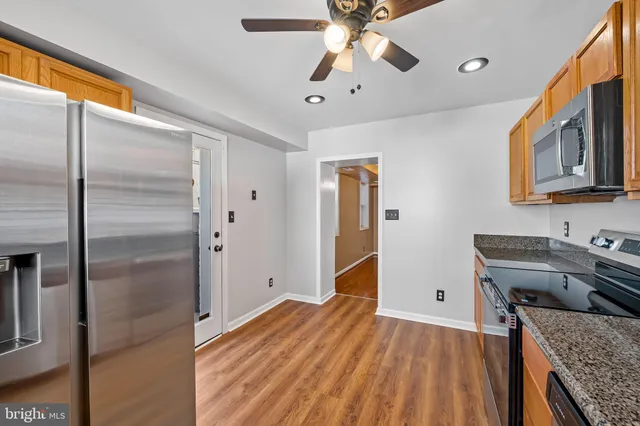 a kitchen with stainless steel appliances granite countertop a refrigerator and a sink