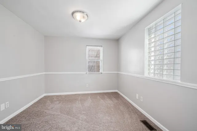 a bedroom with a bed and a flat tv screen on dresser