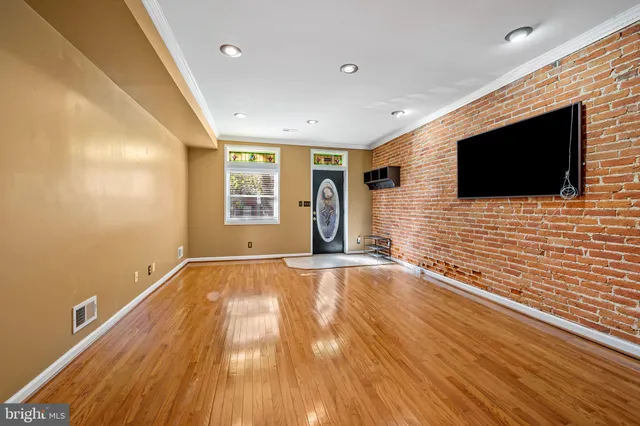 a view of a livingroom with wooden floor and a flat screen tv