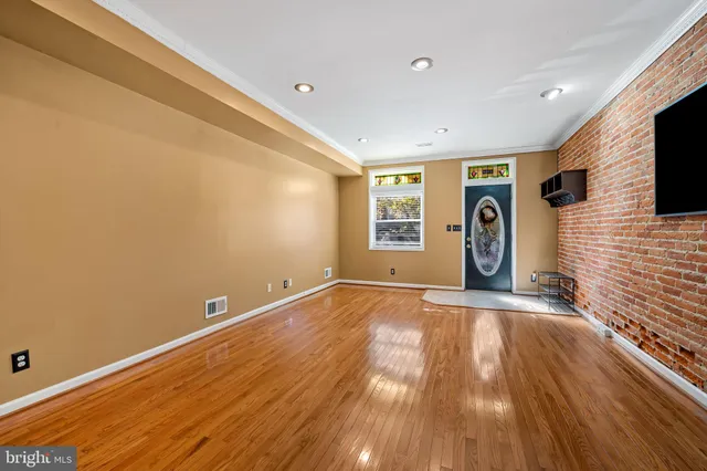 a view of a livingroom with wooden floor and a window