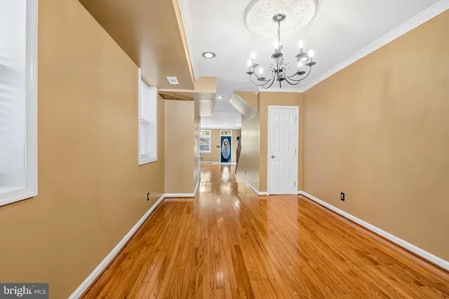 a view of a room with wooden floor and chandelier