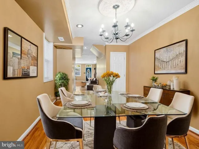 a view of a dining room with furniture a chandelier and wooden floor