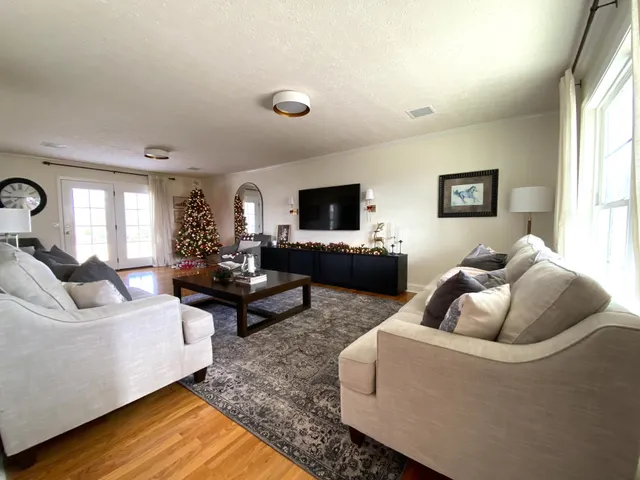 a living room with furniture and a wooden floor
