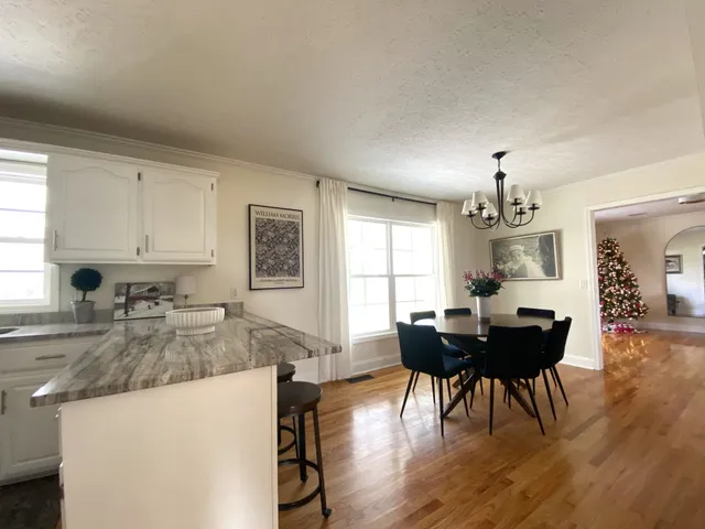 a kitchen with granite countertop a refrigerator a stove top oven a sink dishwasher and wooden cabinets