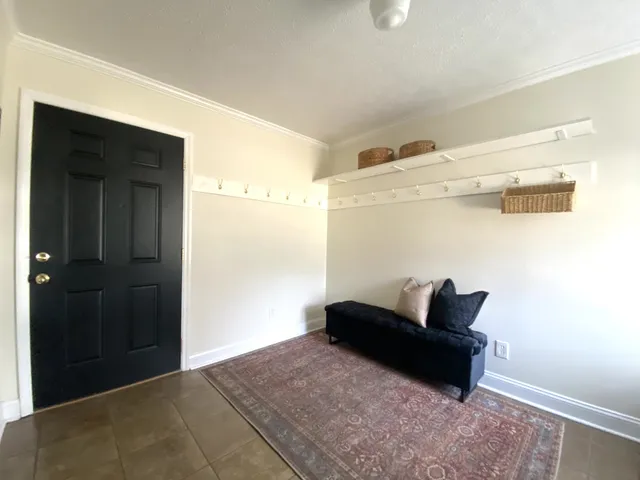 a white kitchen with wooden floor and stainless steel appliances