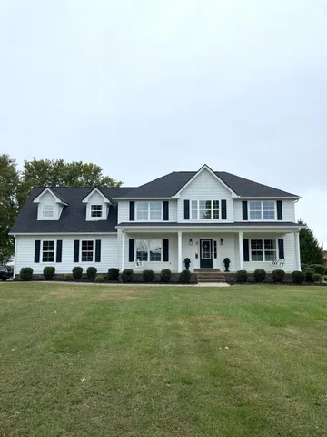 a view of an house with a yard and street