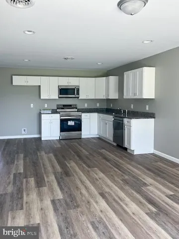 a kitchen with granite countertop a stove and cabinets