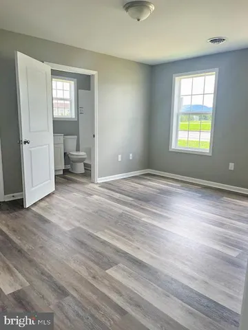 an empty room with windows and cabinet