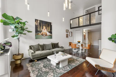 a living room with furniture a flat screen tv and a window