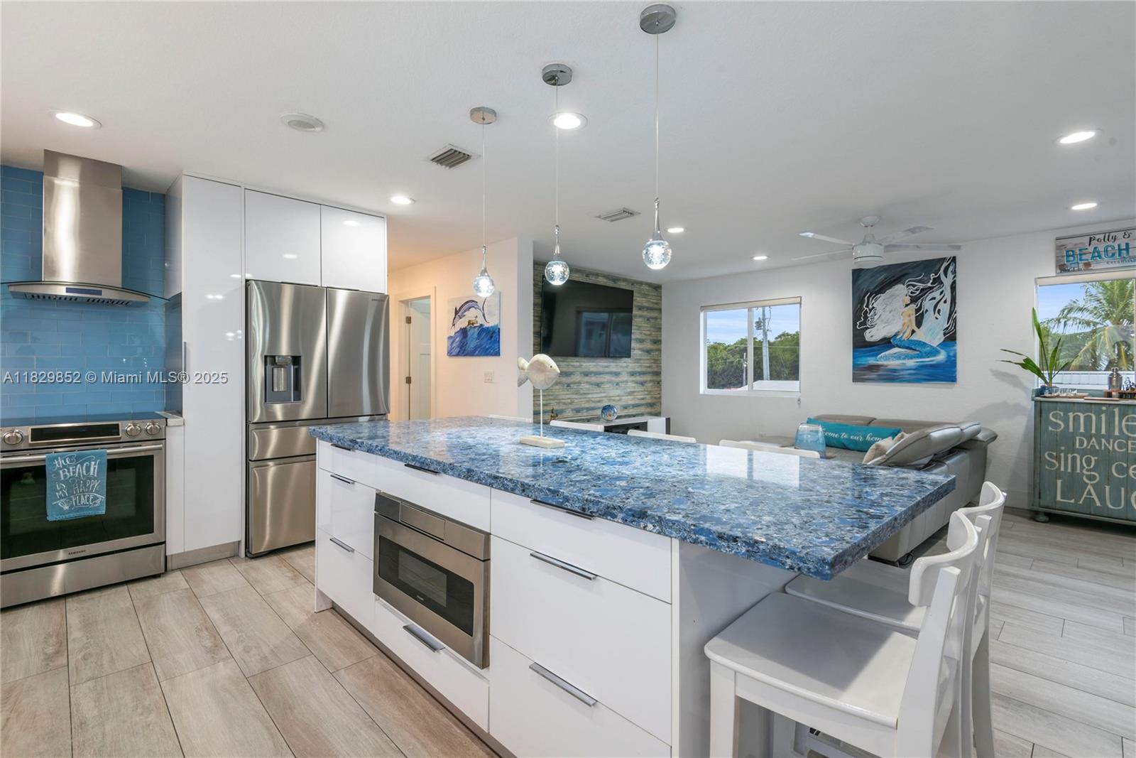 325 Calusa Street Key Largo, FL 33037 - Photo 6 of 17 a kitchen with stainless steel appliances granite countertop a kitchen island hardwood floor sink stove and refrigerator
