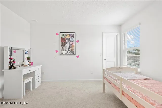 a room with a bed and a dresser next to a window