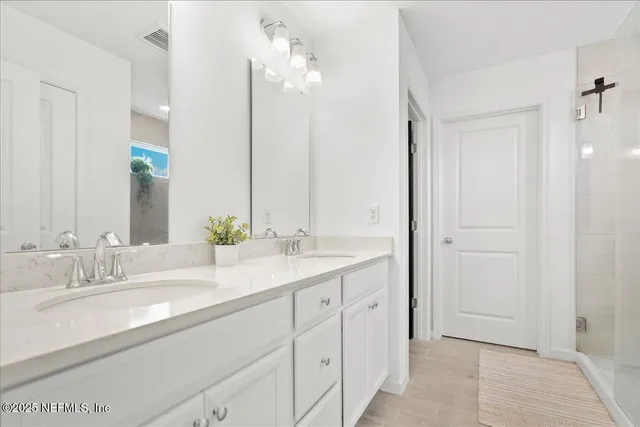 a bathroom with a double vanity sink and a mirror