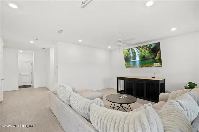 a living room with furniture a flat screen tv and a fireplace