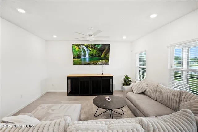 a living room with furniture a fireplace and a large window