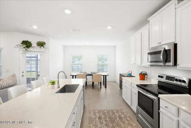 a large white kitchen with stainless steel appliances