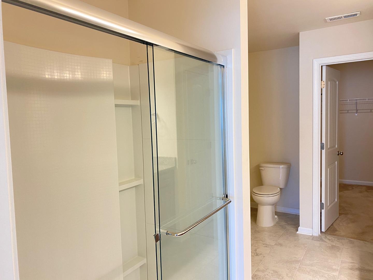 1005 Saffron Loop Durham, NC 27713 - Photo 12 of 26 a bathroom that has a glass shower door
