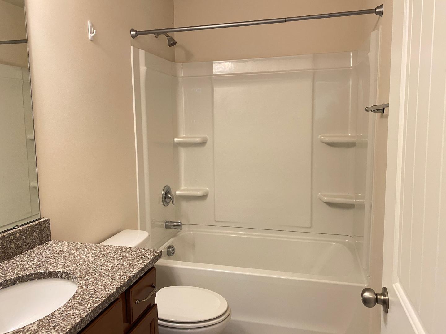 1005 Saffron Loop Durham, NC 27713 - Photo 15 of 26 a bathroom with a granite countertop sink toilet and shower