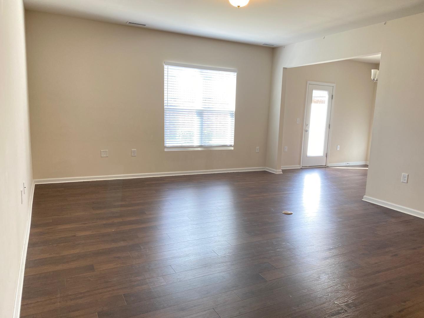 1005 Saffron Loop Durham, NC 27713 - Photo 4 of 26 an empty room with wooden floor and windows