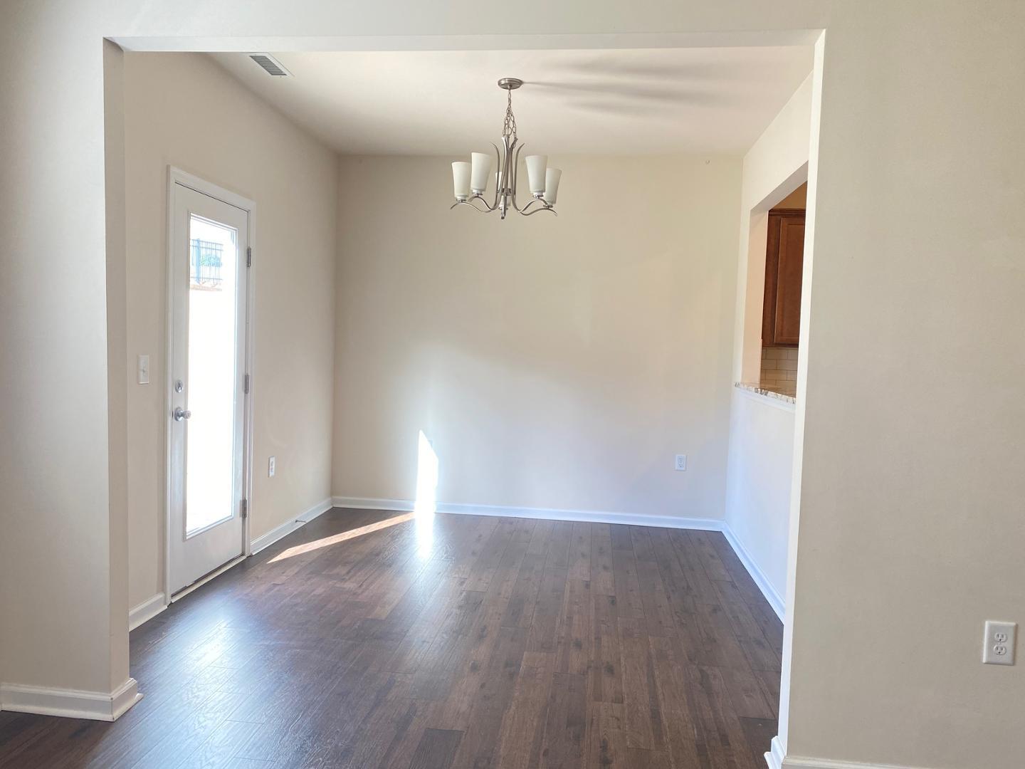 1005 Saffron Loop Durham, NC 27713 - Photo 6 of 26 an empty room with wooden floor and windows